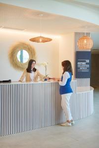 two women shaking hands at a counter in an office at The Editory by the Sea Lagos in Lagos +70 photos