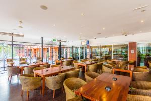 un restaurante con mesas y sillas de madera y ventanas en Markets Hotel, en Sídney