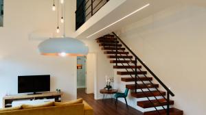 a living room with a staircase and a television at Oak Retreat House in Lagoa