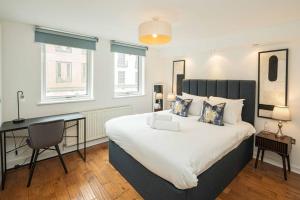 ein Schlafzimmer mit einem großen Bett und einem Schreibtisch in der Unterkunft Stylish 3BD Flat in Prime Covent Garden Location in London + 22 Fotos