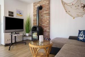 KamminkeにあるBungalow Karstenの暖炉とテレビのあるリビングルーム