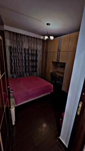 a small bedroom with a red bed in a room at شقه مفروشه in Jurf ad Darāwīsh