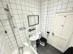 a white bathroom with a sink and a toilet at Bournemouth's Hidden Garden Apartment in Bournemouth +12 photos