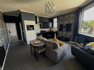 a living room with a couch and a table at Bournemouth's Hidden Garden Apartment in Bournemouth