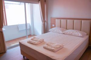 ein Schlafzimmer mit einem Bett, auf dem zwei Handtücher liegen in der Unterkunft Apartment Near Big Buddha in Bangkok Yai