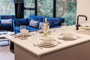 a kitchen with a table with plates and wine glasses at Aurora South - Short Walk to Ashley Cross in Poole