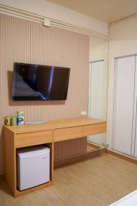 Zimmer mit einem Schreibtisch und einem TV an der Wand in der Unterkunft Apartment Near Big Buddha in Bangkok Yai