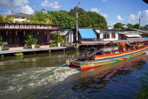 a boat in the water next to a building at Apartment Near Big Buddha in Bangkok Yai