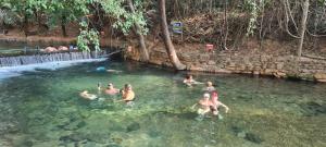 a group of people swimming in a pool of water at Rio Quente Aguas da Serra Apart 008B in Rio Quente