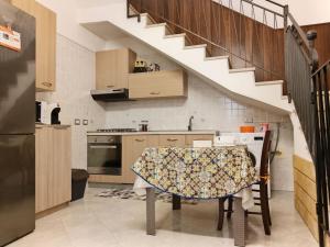a kitchen with a table and a stairway at Casa Sciacca: La Tua Casa Vacanze Ideale a Marsala in Marsala