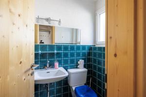 a blue tiled bathroom with a toilet and a sink at Feriensiedlung Tru 19 in Scuol +24 photos