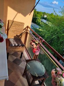 a balcony with a chair and a vase of flowers at Apartament Królewskie Pawie in Sandomierz +9 photos