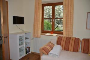 salon z kanapą i oknem w obiekcie Apartment Grössenberg w mieście Weißkirchen in Steiermark