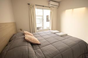 a bedroom with a bed with two pillows and a window at Complejo Coirón in San Rafael