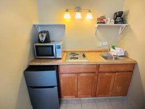 a small kitchen with a microwave and a sink at Sunrise Motel in York