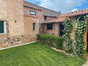 a house with a green yard next to a building at La Lechería de Daniela in Granja de Moreruela