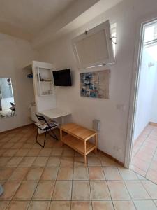 a living room with a desk and a tv at Favignana KasAle in Favignana