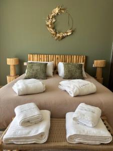 a bed with towels on it with a wreath on the wall at La Maison d'Ambrine - Villa Grignan in Grignan +53 photos