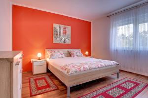 sypialnia z pomarańczowymi ścianami i łóżkiem w pokoju w obiekcie Apartment Korpar w Medulinie