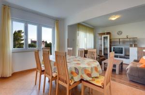 jadalnia i salon ze stołem i krzesłami w obiekcie Apartment Korpar w Medulinie