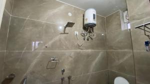 a shower with a blow dryer in a bathroom at Somnath Dham By YatriMap in Rāiwāla