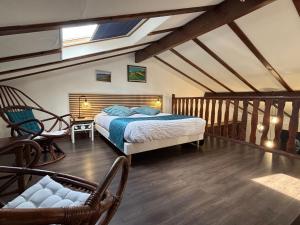 a bedroom with a bed and a chair at Domaine de Hurlevent in Montgaillard-Lauragais