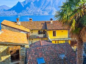 a yellow house with a palm tree and a mountain at La Palma in Ghiffa +34 photos