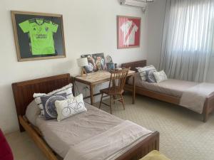 a bedroom with two beds and a table with a desk at Excepcional casa en barrio privado in Yerba Buena +9 photos