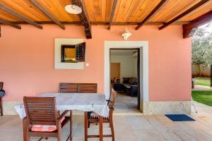 eine Terrasse mit einem Tisch und Stühlen sowie ein Haus in der Unterkunft Apartments Aldo in Banjole