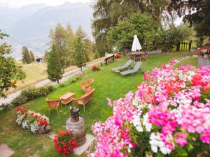 a garden with flowers and a table and chairs at Chaletbethere in Pila