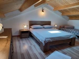 sypialnia z dużym łóżkiem z niebieską pościelą i drewnianymi sufitami w obiekcie Holiday Home Orihi w mieście Barban