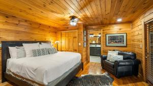 a bedroom with a bed and a leather chair at Cozy Black Bear Cabin porch swing & stunning views in Sevierville