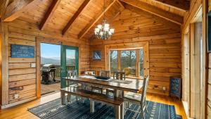 a dining room with a table and chairs in a cabin at Cozy Black Bear Cabin porch swing & stunning views in Sevierville
