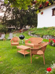a group of chairs and a grill in the grass at Chaletbethere in Pila