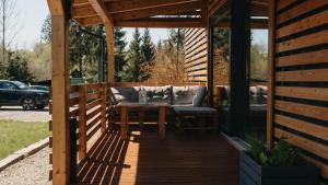 a wooden pergola with a table and chairs on a patio at Woodbox Istebna in Istebna