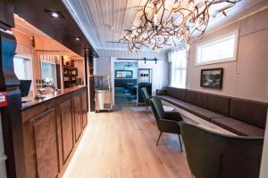 a bar with a couch and chairs in a restaurant at Heartbreak Hotel in Nedre Heidal