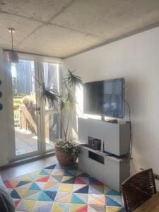 バルパライソにあるLoft Cerro Alegre Valparaísoのテレビとカラフルな床のあるリビングルーム