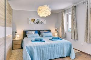 a bedroom with a bed with blue pillows on it at Villa Sonja in Medulin +45 photos