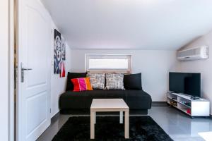salon z kanapą i telewizorem w obiekcie House Kapovica w Medulinie