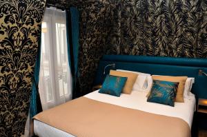 a bedroom with a bed with a blue and black wall at Hôtel du Mont Blanc in Paris