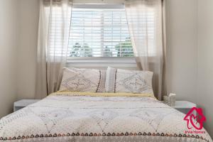 a bedroom with a bed with a window and pillows at Chapala Charm 6BR Family Oasis - An Irvie Home in Albuquerque