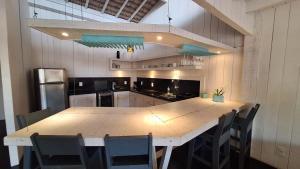 a kitchen with a large wooden table and chairs at As Palhas in Icaraí +7 photos