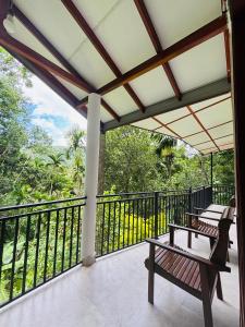 balcón con 2 bancos y barandilla en Madiriya Forest Lodge, en Badulla
