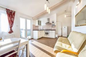 eine Küche und ein Wohnzimmer mit Sofa und Tisch in der Unterkunft Apartments Ivonne in Ližnjan