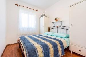 ein Schlafzimmer mit einem Bett mit blauen Kissen in der Unterkunft Apartments Ivonne in Ližnjan