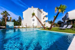 デニアにあるLuxury Apartment Denia with Pool & Montgó Viewのヤシの木が茂る家の前のスイミングプール