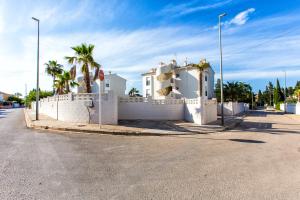 デニアにあるLuxury Apartment Denia with Pool & Montgó Viewの椰子の木と柵のある白い家