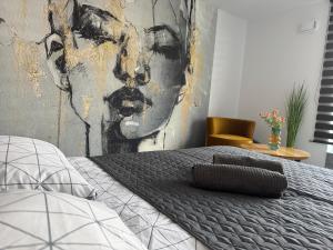 a bedroom with a bed with a painting on the wall at New Apart Smart- OAZA RELAKSU-Rynek Central Kielce - Parking -fak VAT- rok budowy 2025 in Kielce