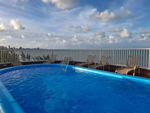 a large blue swimming pool on top of a building at Flat à beira mar, charmoso e aconchegante in João Pessoa