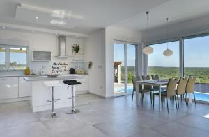 a kitchen and dining room with a table and chairs at Villa White in Barbariga
